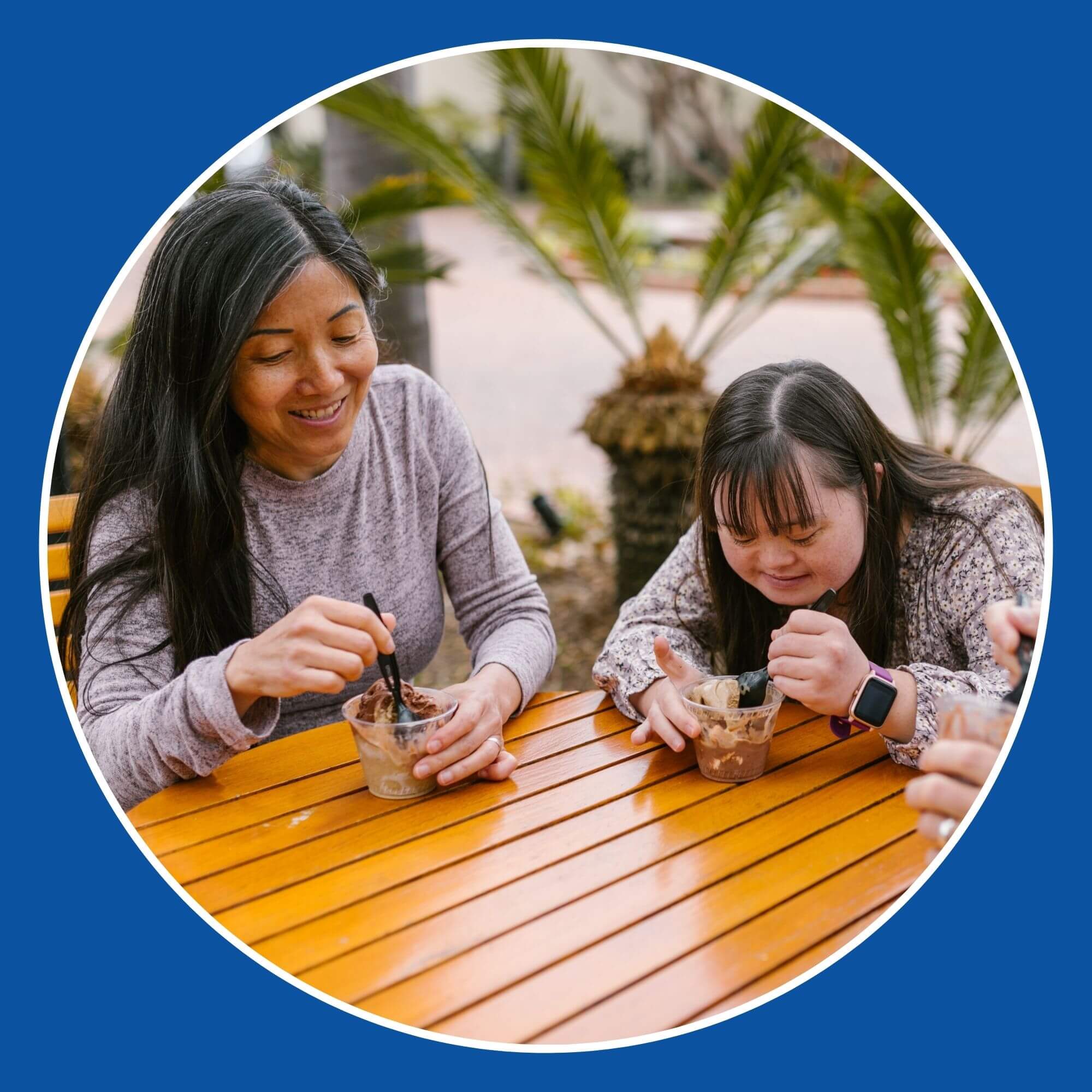 Photo showing a family with a daughter with Downs Syndrome, eating ice cream on an outside table. Photo from Pexels (Photographer Rodnae Productions)