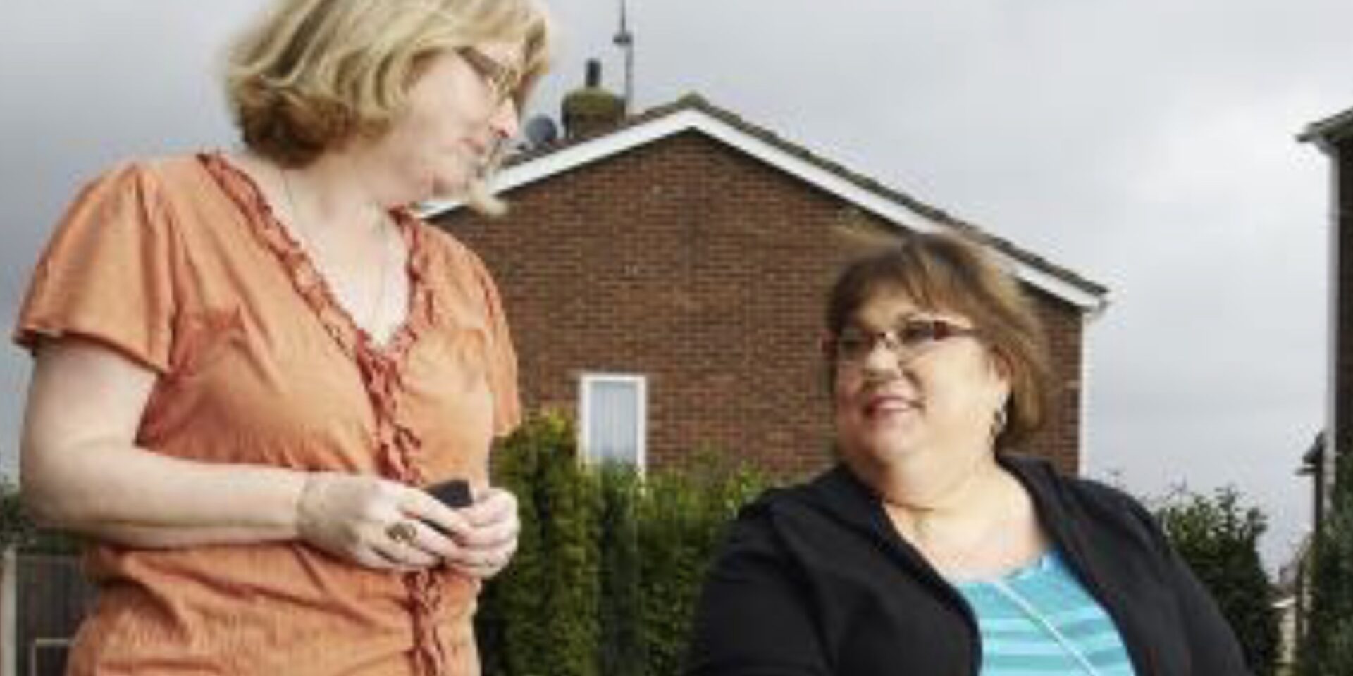 Image showing two ladies talking outside, one in a mobility scooter and one walking