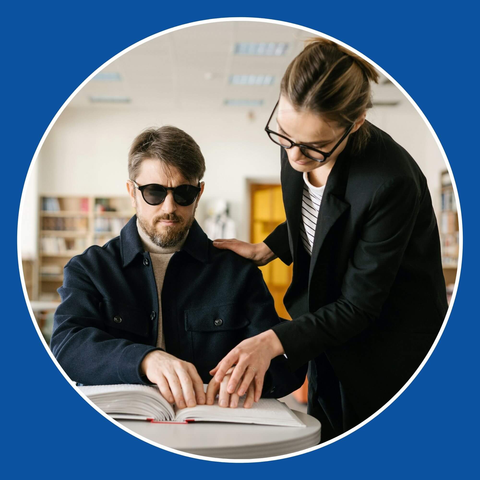 A lady helping a blind gentleman read a braille book in a library. Photo from Pexels (Photographer is Mikhail Nilov)